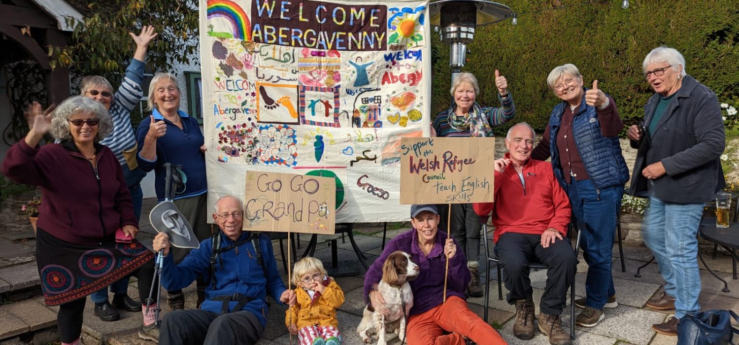 A photograph of Harry Iles and supporter s after he completed the Three Peaks challenge to raise funds for asylum seekers.